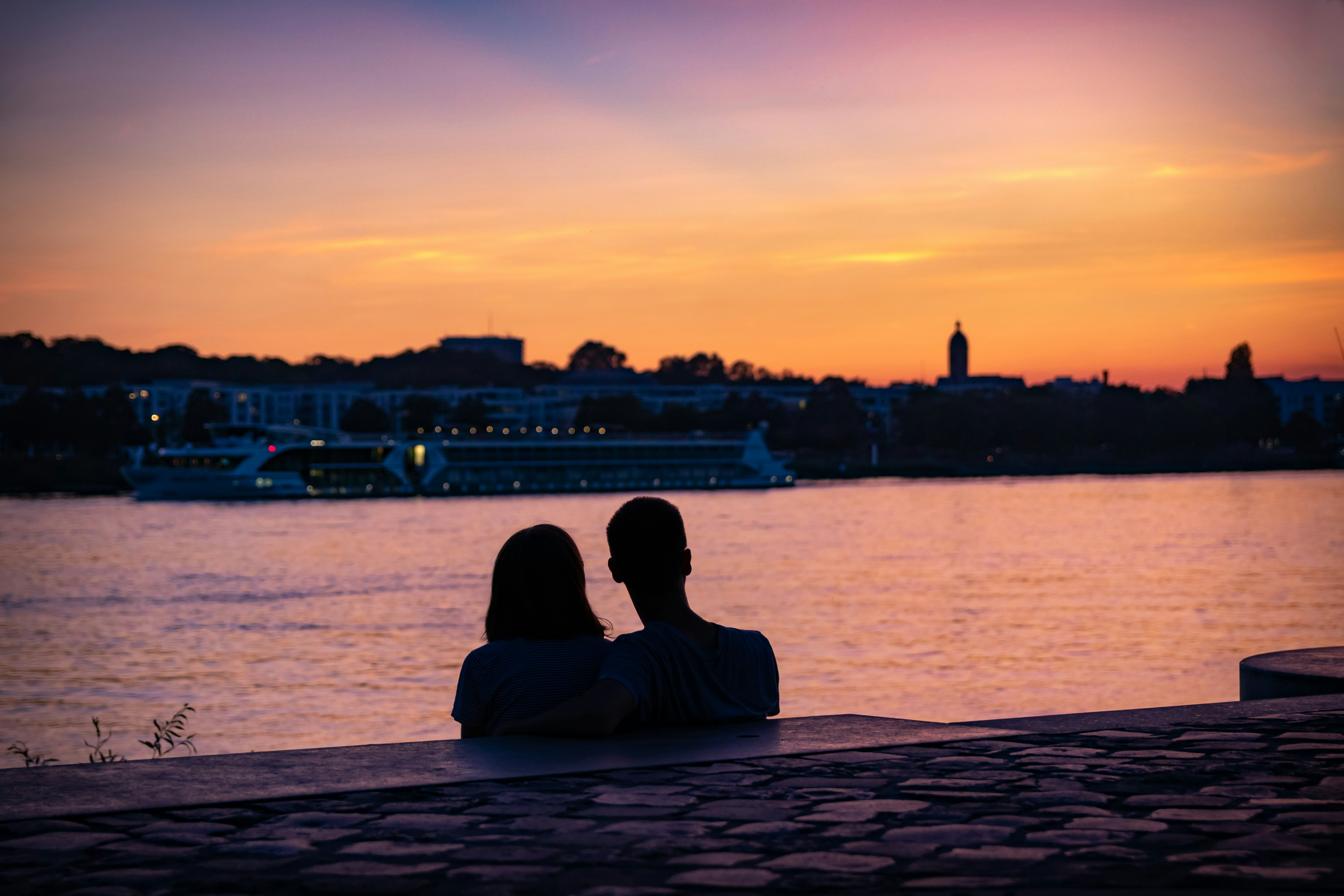 A couple enjoying sunset at the Rhine promenade, Mainz, Germany